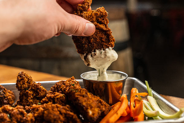 Chicken Tender Being Dipped in Sauce